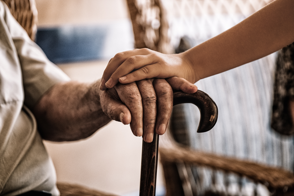 carer holding an elderly persons hand